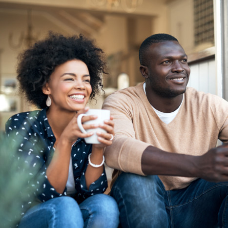 Couple drinking coffee on balcony | Creekstone Village